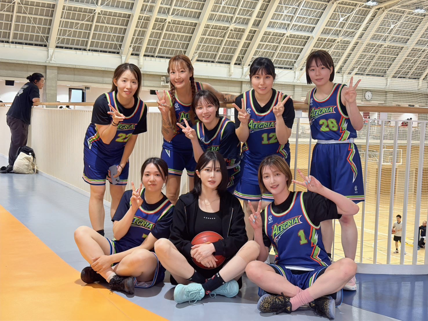 アレグリアガールズのチーム集合写真（体育館のコートを背に）